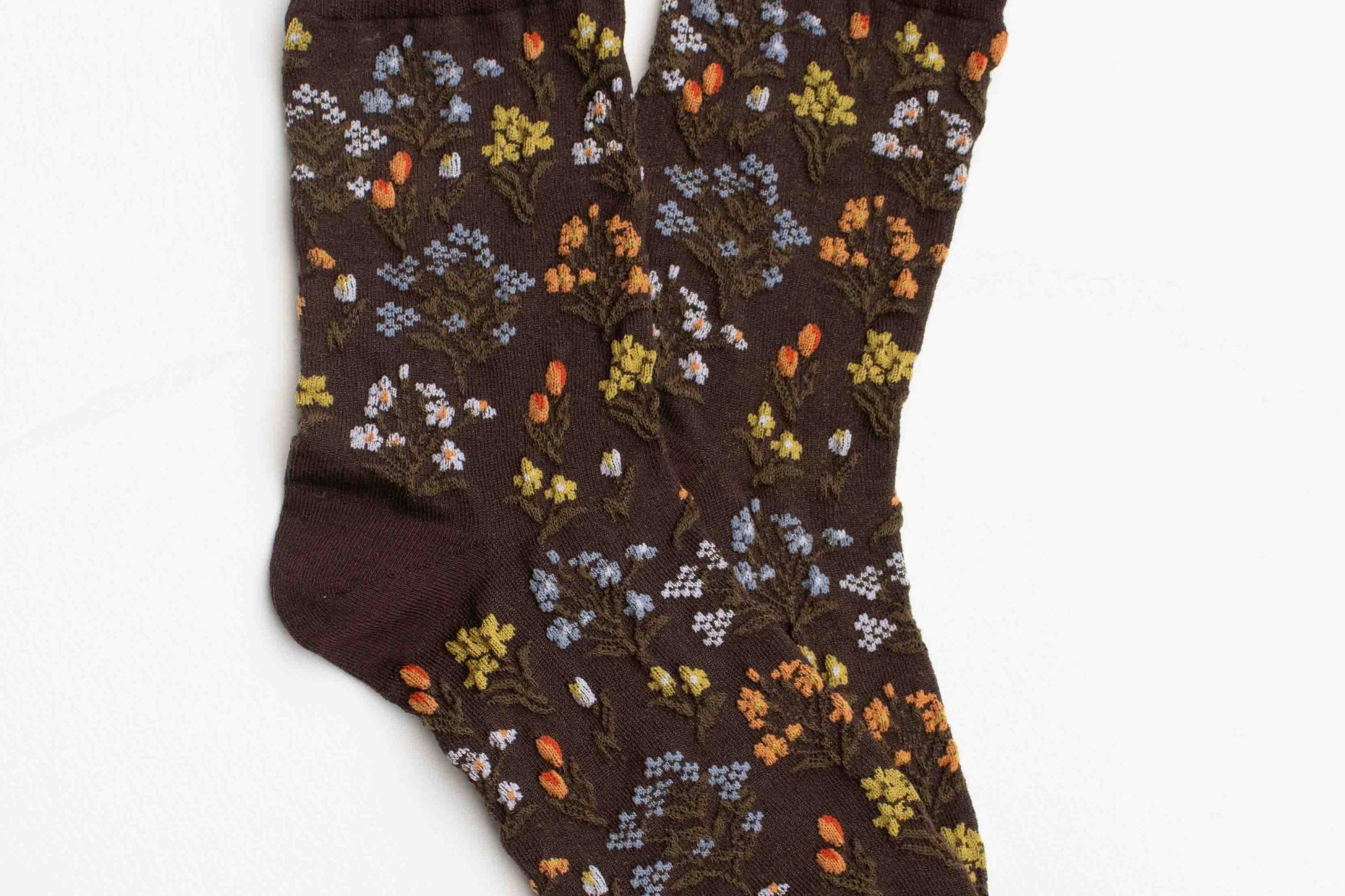 Pair of brown socks with floral pattern on a white background