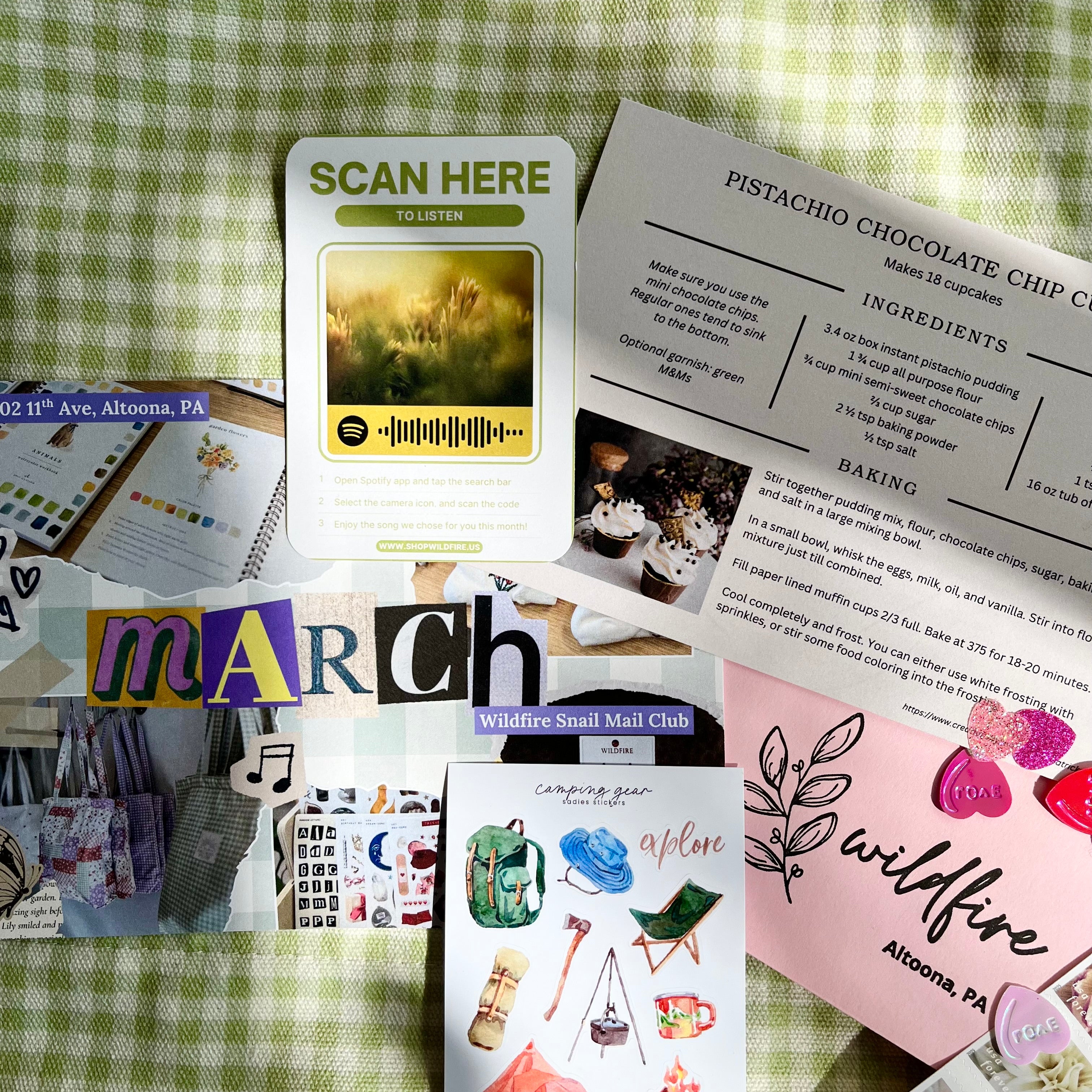 Collection of cards and stationery items on a green checkered fabric background