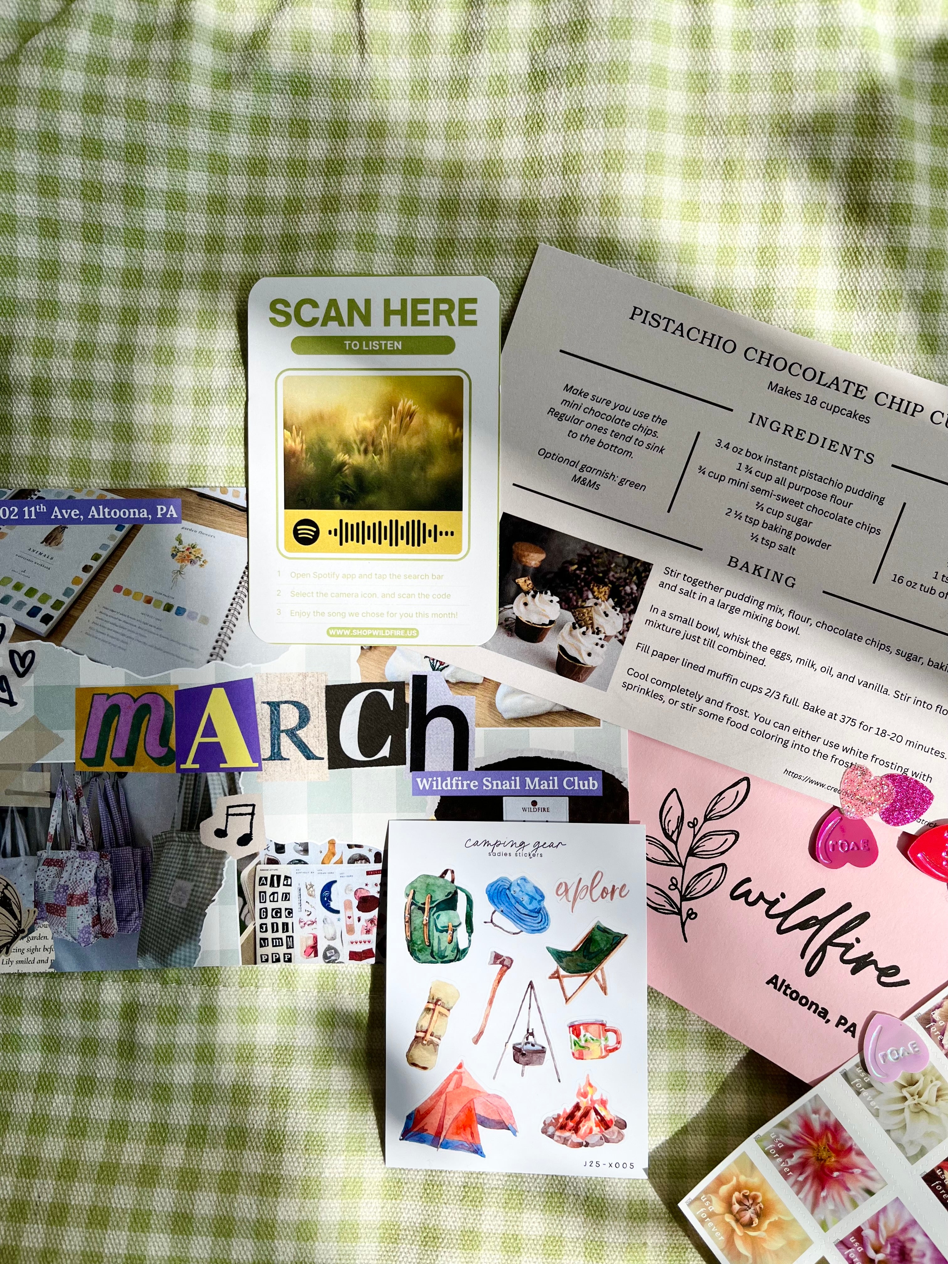 Collection of cards and stationery items on a green checkered fabric background