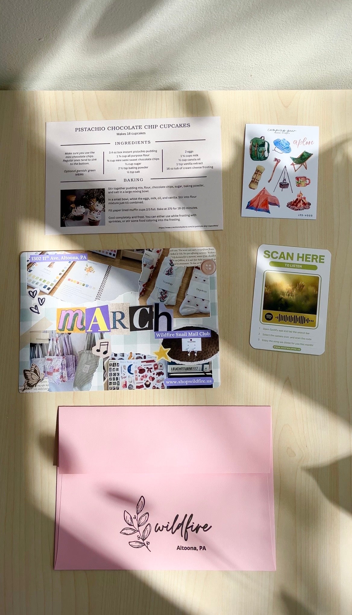 Collection of printed materials on a wooden surface with 'wildfire' branding.