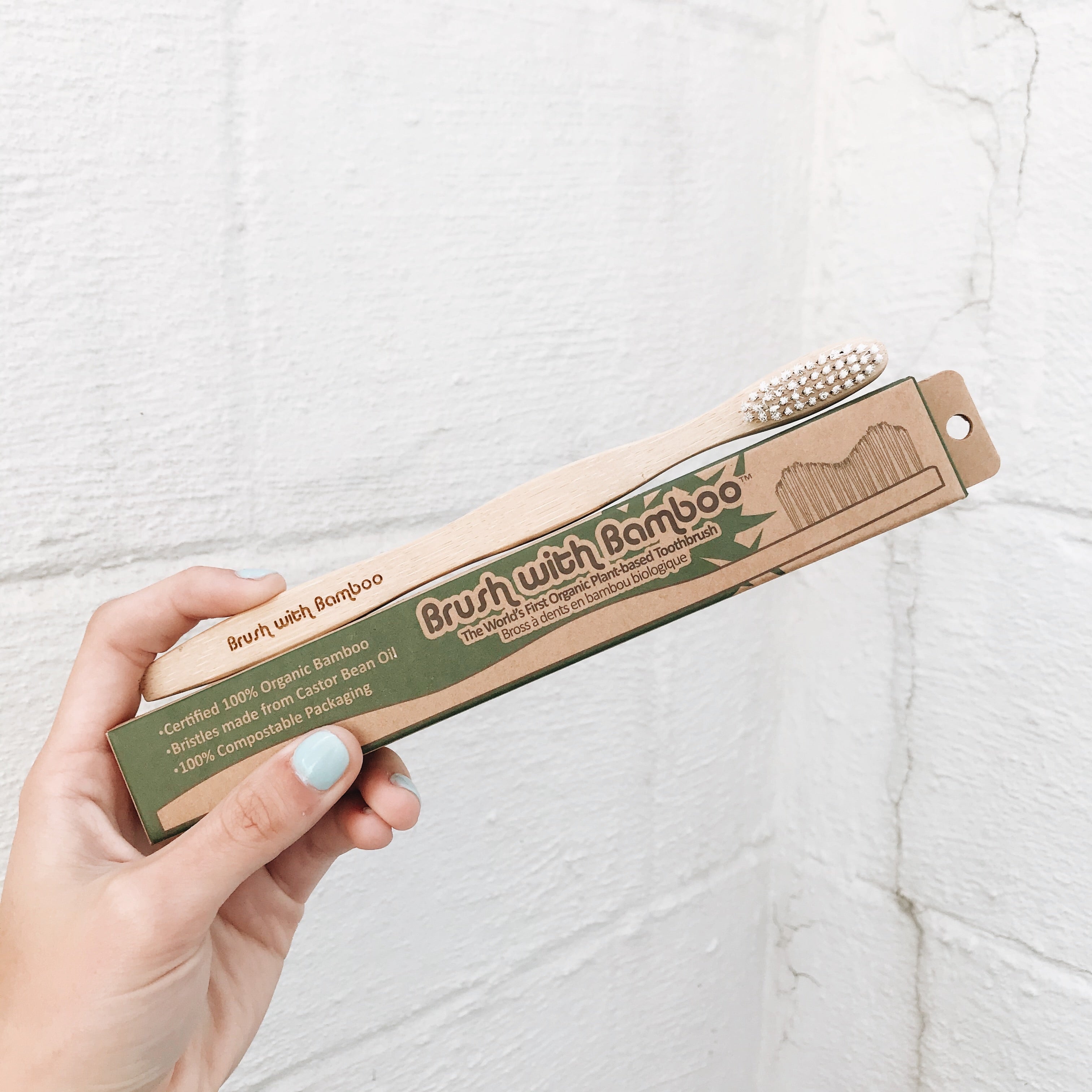 This bamboo toothbrush comes in eco-friendly packaging. Because it is made of paper, it can be composted after opened. The toothbrush itself is made of bamboo and has soft, white bristles.